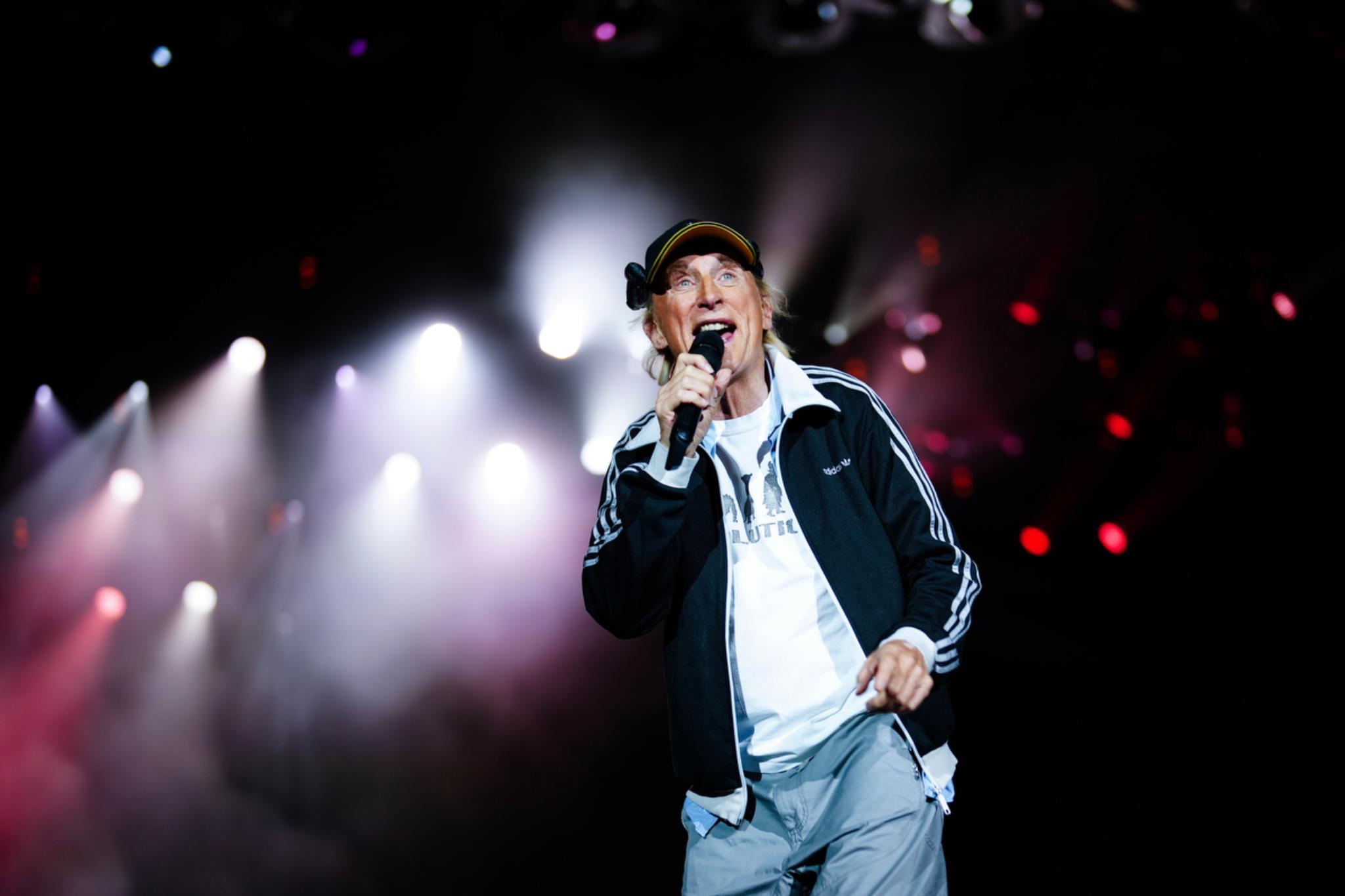 Otto Waalkes singing on stage with bright stage lights in the background © Eva Manhart, All rights reserved