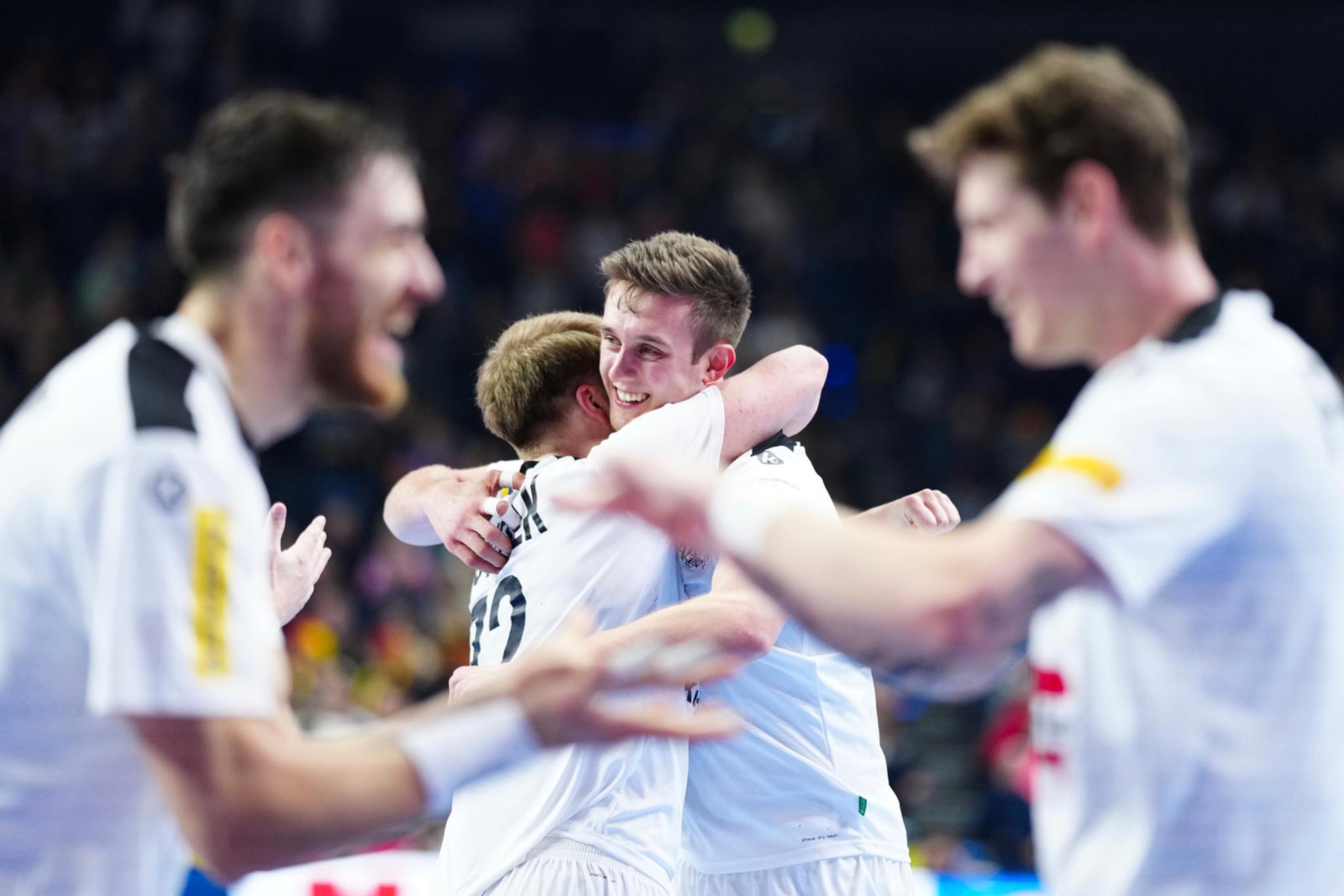 Two athletes in white jerseys embracing each other in celebration, with two other teammates in the foreground also appearing joyful The background is blurred, indicating a dynamic and energetic environment, likely a sports event © Eva Manhart, All rights reserved